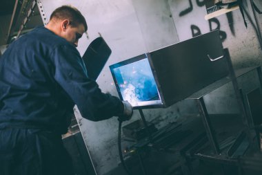 Metalurji Sanayi. Fabrika üretim ağır Pelet soba ve kazanlar için. Onun iş işçi ressam. Son derece karanlık koşulları ve görünür gürültü