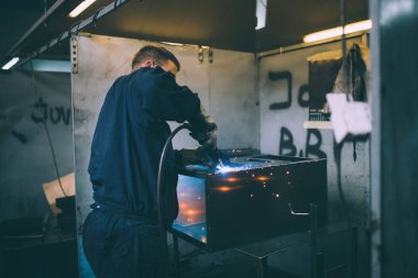 Metalurji Sanayi. Fabrika üretim ağır Pelet soba ve kazanlar için. Onun iş işçi ressam. Son derece karanlık koşulları ve görünür gürültü