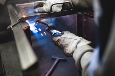 Metalurji Sanayi. Fabrika üretim ağır Pelet soba ve kazanlar için. İşçi Kaynakçı işini üzerine kapatın. Son derece karanlık koşulları ve görünür gürültü