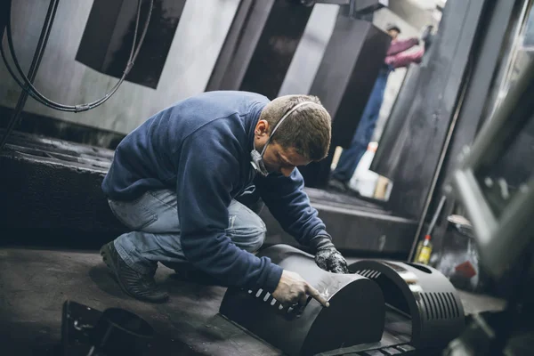 Metalurji Sanayi. Fabrika üretim ağır Pelet soba ve kazanlar için. Onun iş işçi ressam. Son derece karanlık koşulları ve görünür gürültü