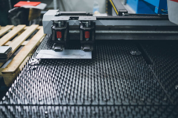 Metallurgy industry. Interior details from factory for production of heavy pellet stoves and boilers. Extremely dark conditions and visible noise. Focus on foreground