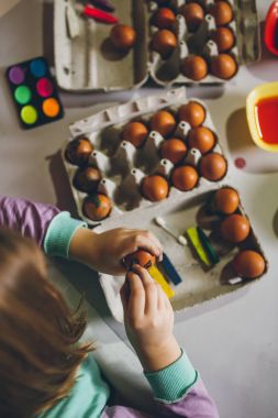 Paskalya tatil keyfi küçük kız. Boyama ve yumurta dekorasyon mutfak masasında oturuyor