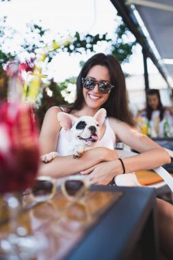 Fransız bulldog köpek kafe barda ile zevk güneş gözlüklü güzel genç kadın