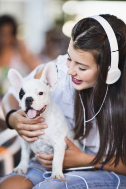 Sevimli Fransız bulldog köpeği ile kafede oturan güzel genç kadın. Açık havada bahar ya da yaz şehir. Köpekler Tema grubu