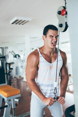 Egzersiz ve fitness spor salonunda ağırlık kaldırma işi genç çekici yetişkin bir adam. Kapalı eğitim spor