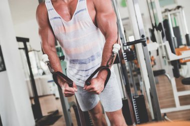 Egzersiz ve fitness spor salonunda ağırlık kaldırma işi genç çekici yetişkin bir adam. Kapalı eğitim spor