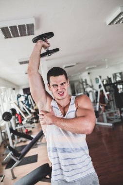 Egzersiz ve fitness spor salonunda ağırlık kaldırma işi genç çekici yetişkin bir adam. Kapalı eğitim spor