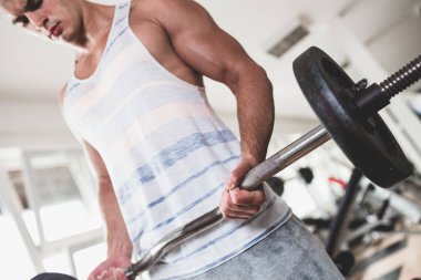 Egzersiz ve fitness spor salonunda ağırlık kaldırma işi genç çekici yetişkin bir adam. Kapalı eğitim spor