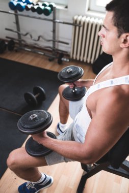 Egzersiz ve fitness spor salonunda ağırlık kaldırma işi genç çekici yetişkin bir adam. Kapalı eğitim spor