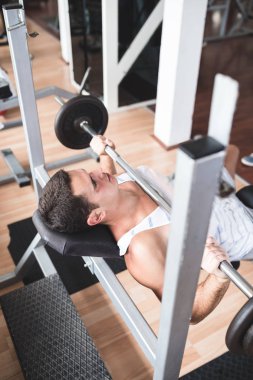 Egzersiz ve fitness spor salonunda ağırlık kaldırma işi genç çekici yetişkin bir adam. Kapalı eğitim spor