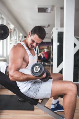 Egzersiz ve fitness spor salonunda ağırlık kaldırma işi genç çekici yetişkin bir adam. Kapalı eğitim spor