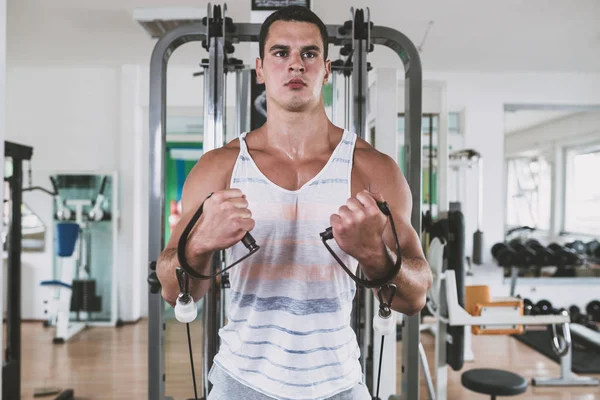 Egzersiz ve fitness spor salonunda ağırlık kaldırma işi genç çekici yetişkin bir adam. Kapalı eğitim spor