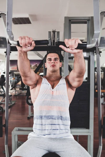 若い魅力的な大人男性運動やフィットネスのジムで重量挙げをやってします スポーツ屋内トレーニング — ストック写真