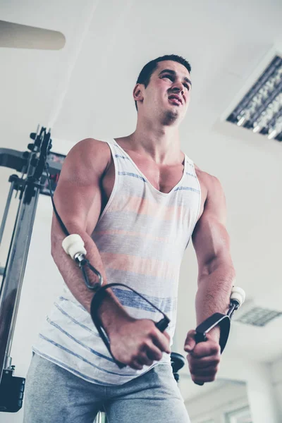若い魅力的な大人男性運動やフィットネスのジムで重量挙げをやってします スポーツ屋内トレーニング — ストック写真