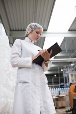 Şişeleme ve saf içme suyu içine şişe ve teneke kutu ambalaj için robot satır kontrol işçisi genç kadın