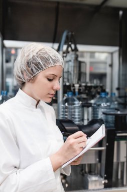 Şişeleme ve saf içme suyu içine şişe ve teneke kutu ambalaj için robot satır kontrol işçisi genç kadın