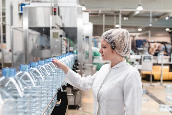 Młoda Kobieta Pracownik Kontroli Zautomatyzowanych Linii Rozlewania Pakowania Czystej Wody — Zdjęcie stockowe