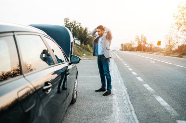 Araba arızası ya da motor arızası. Zarif orta yaşlı adam yolda araba kazası için çekici servisi bekliyor. Yol kenarı yardım kavramı.