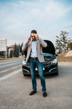 Zarif bir orta yaşlı iş adamı yolda yardım için çekici servisini arıyor. Yol kenarı yardım kavramı.