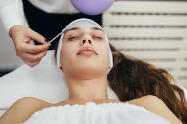 Güzel ve çekici yetişkin kadın profesyonel yüz bakımı görüyor.