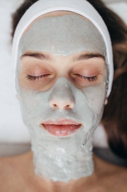 Güzel ve çekici yetişkin kadın profesyonel yüz bakımı görüyor.