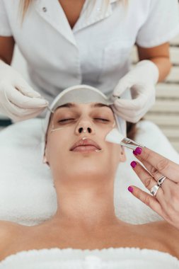 Güzel ve çekici yetişkin kadın profesyonel yüz bakımı görüyor.