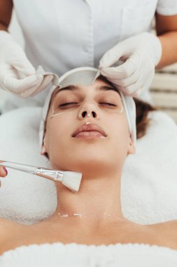 Güzel ve çekici yetişkin kadın profesyonel yüz bakımı görüyor.