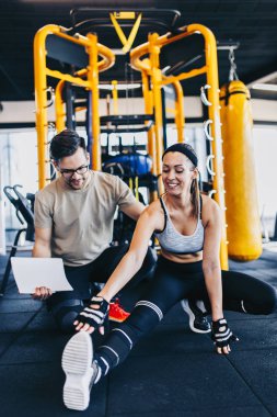 Modern fitness spor salonunda Kettlebell ile alıştırma egzersiz genç fit ve çekici adam ve kadın.