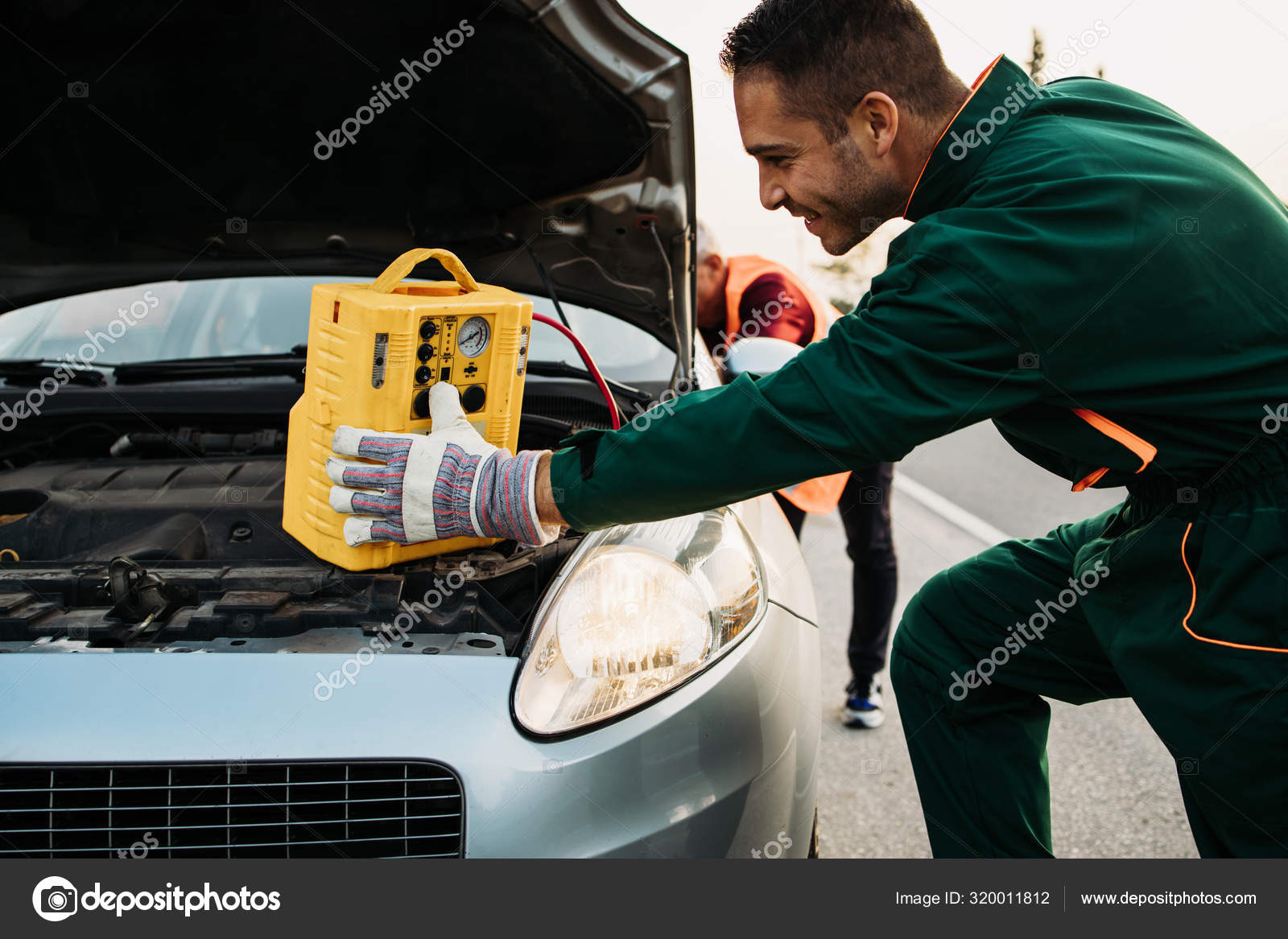 Two Road Assistant Workers Towing Service Trying Start Car Engine