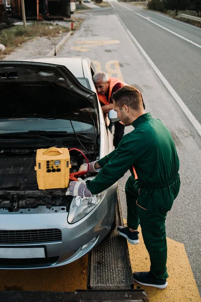 Två Vägassistenter Bogsering Service Försöker Starta Bilen Motor Med Hopp — Stockfoto