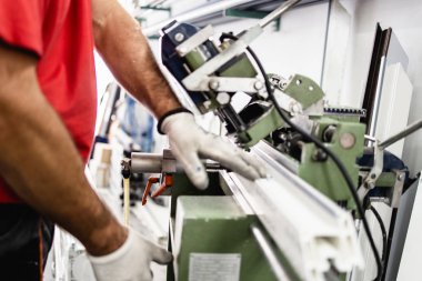 Alüminyum ve PVC profilleri kesen el işi işçisi. İmalat işleri. Seçici odaklanma. Alüminyum ve PVC pencere ve kapı üretim fabrikası.