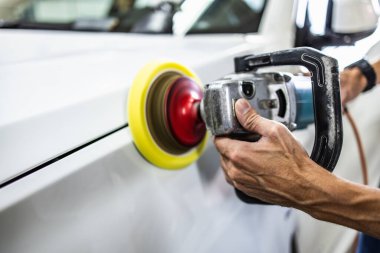 Araba tamiri, oto tamirhanesinde orbital parlatıcıyla el işi. Seçici odak.