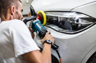 Araba tamiri, oto tamirhanesinde orbital parlatıcıyla el işi. Seçici odak.