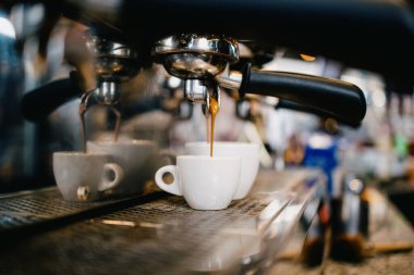 Kahve makinesini yakından çek. Lezzetli, taze ve sıcak kahveyi beyaz fincana dök..