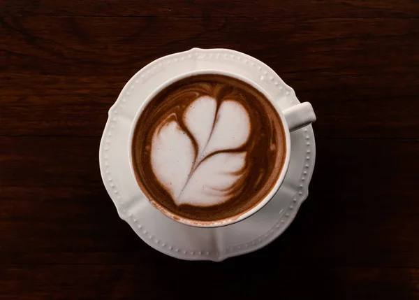 Zbliżenie filiżankę gorącej kawy tulip latte art na stół z drewna, dźwięk w vintage — Zdjęcie stockowe