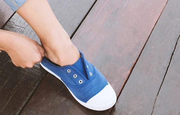 Closeup woman tying sneaker shoes on wood floor, vintage tone — Stock Photo, Image