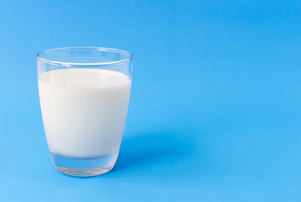 Mavi arka planda bir bardak süt, sağlıklı konsept için yiyecek ve içecek. — Stok fotoğraf