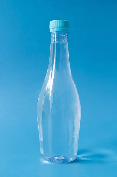 Bottone d'acqua in plastica su fondo blu — Foto Stock