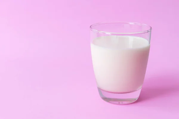 Closeup glas melk op roze achtergrond, eten en drinken voor gezonde concept, selectieve en zachte focus — Stockfoto