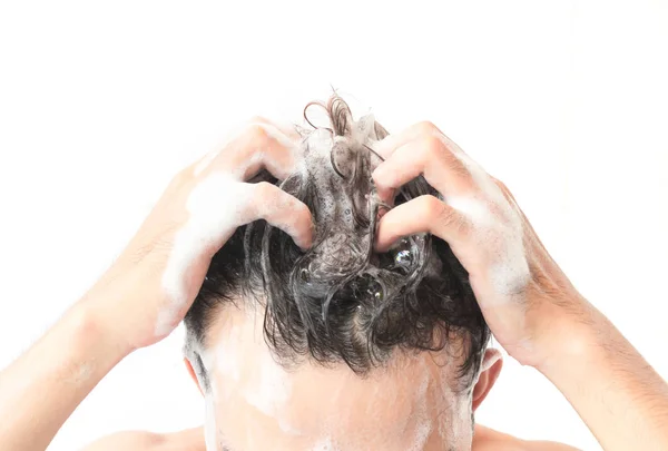 Nahaufnahme junger Mann beim Haarewaschen mit weißem Hintergrund, Gesundheitskonzept — Stockfoto