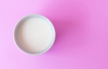 Closeup üstten görünüm süt seçici odak pembe arka plan üzerinde beyaz seramik Kupası