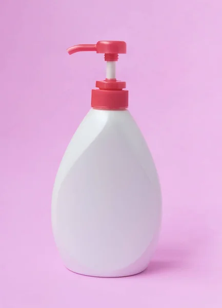 Botella de loción blanca sobre fondo rosa, concepto de cuidado de la piel de belleza — Foto de Stock