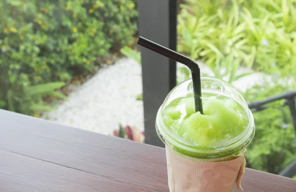 Gros plan de smoothie kiwi en verre plastique sur table, mise au point sélective — Photo