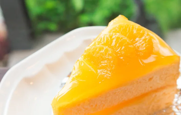 Closeup πορτοκαλί κέικ σε τραπέζι από ξύλο με φόντο φύση — Φωτογραφία Αρχείου