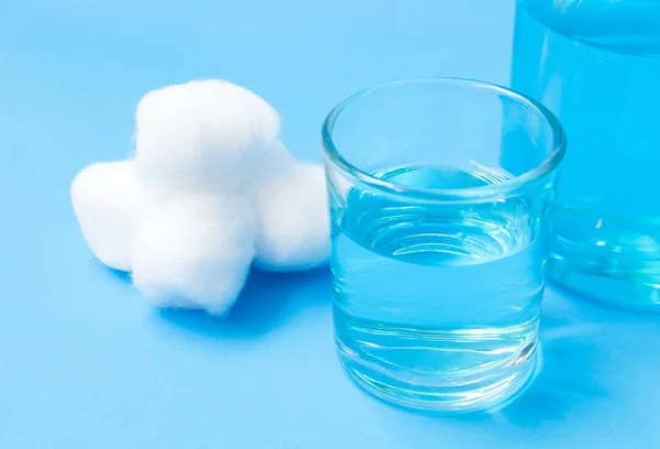 Bottiglia di vetro da primo piano di lana di cotone e alcool blu su ba blu — Foto Stock
