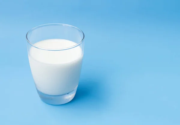 Glas melk op blauwe achtergrond, eten en drinken voor gezonde con — Stockfoto
