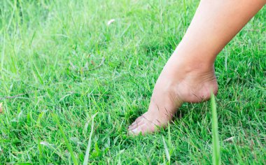 Kadın bacaklar duygu ışık yeşil çim zemin üzerine dinlenmek