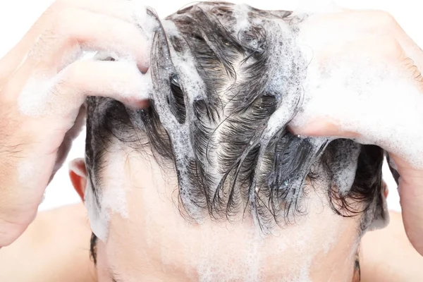 Closeup jovem homem lavar o cabelo com fundo branco, conceito de cuidados de saúde — Fotografia de Stock