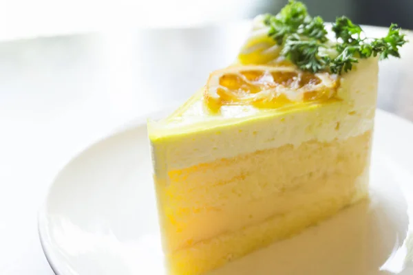 Primer plano pastel de limón en plato blanco en la cafetería para relajarse concepto de tiempo, enfoque selectivo — Foto de Stock