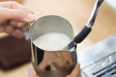Closeup akışı süt için yapmak kahve latte sanat makine, seçici ve yumuşak odak ile sıcak